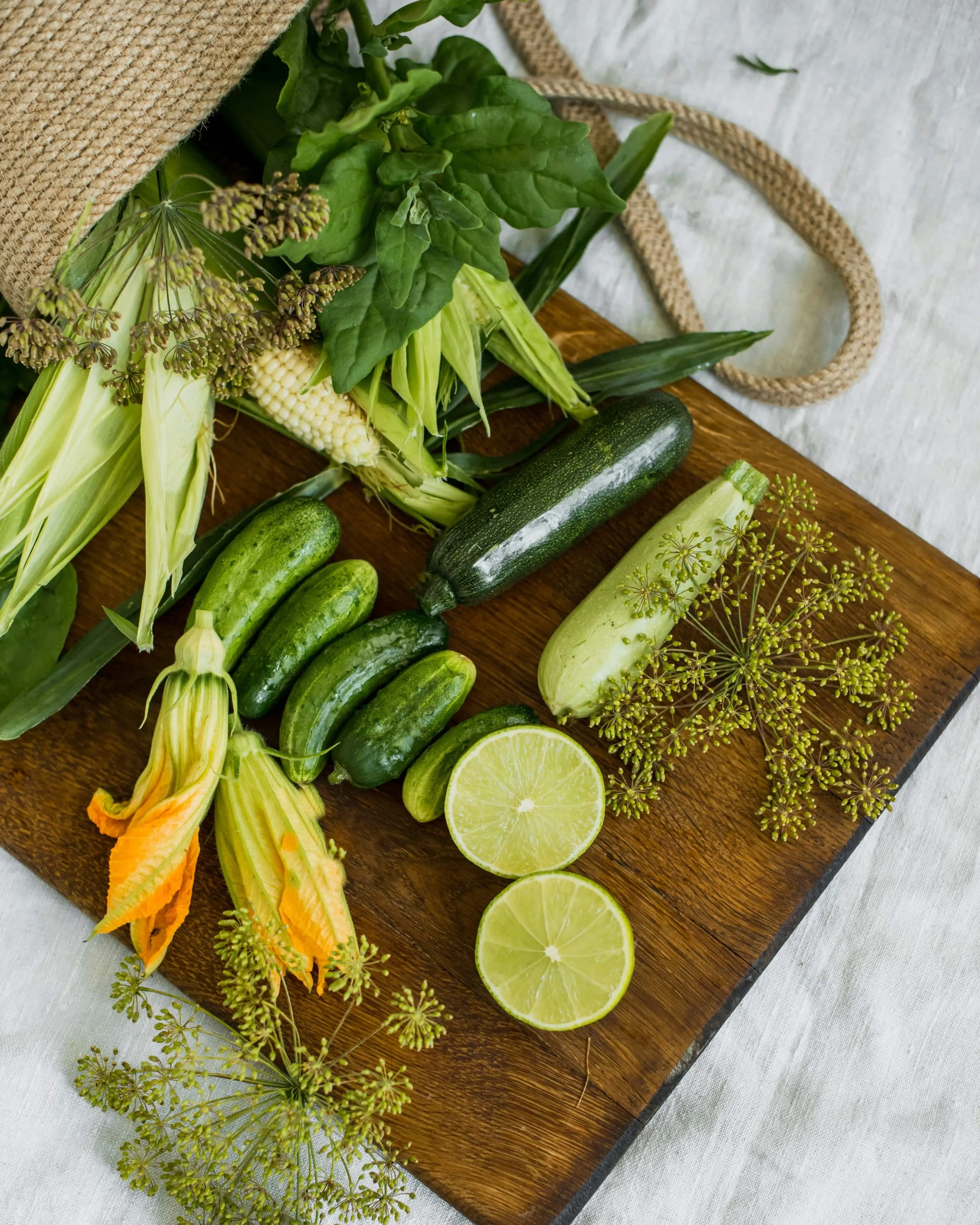 Osoba trzyma seler, cukinię, brokuł i pietruszkę.